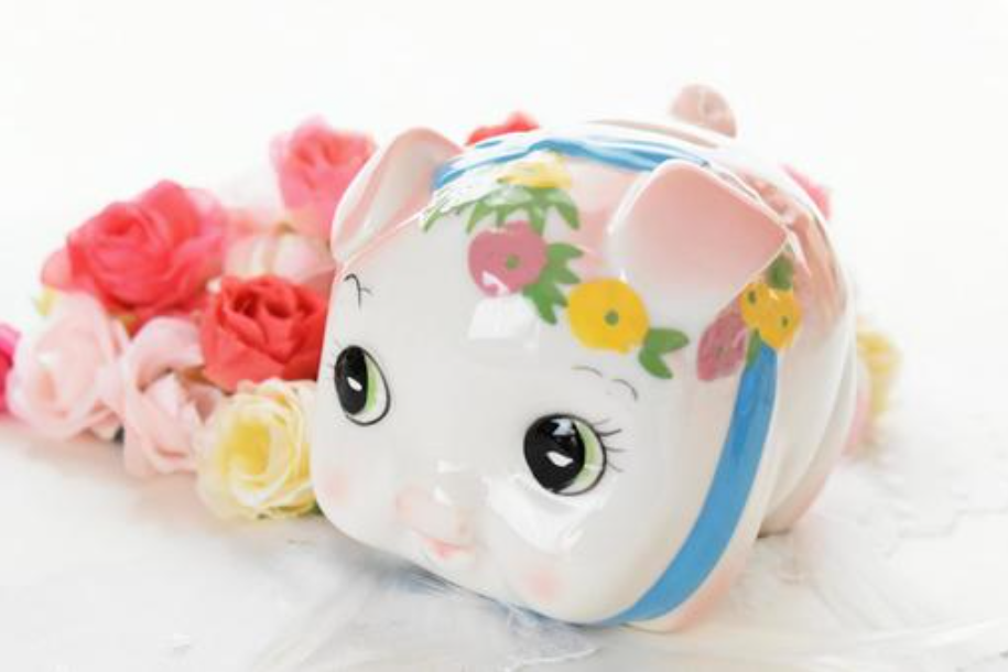 豚の貯金箱とバラの花・イメージ画像